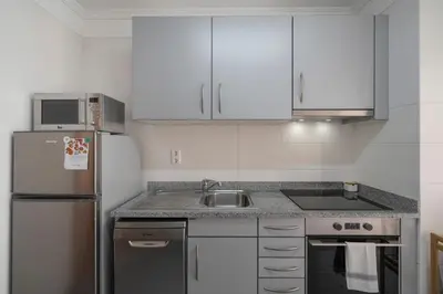 a kitchen with white cabinets and a stainless steel refrigerator at Green Park by An Island Apart in Funchal