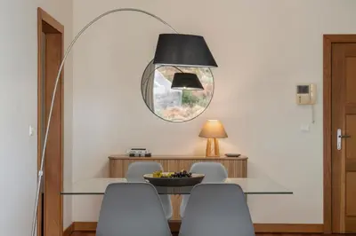 a dining room with a table and chairs and a mirror at Green Park by An Island Apart in Funchal