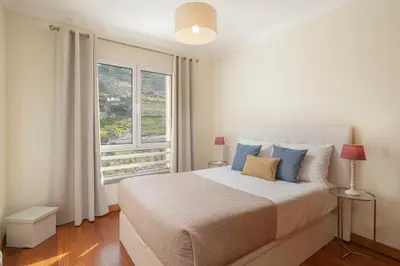 a bedroom with a bed and a large window at Green Park by An Island Apart in Funchal