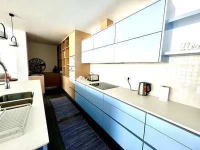 a kitchen with blue and white cabinets and a sink at Luz Vila in Luz