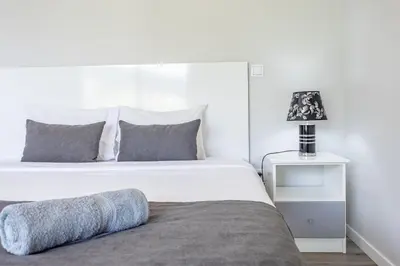 a bedroom with a bed and a lamp on a night stand at Paradise Pereira House BY YOUR KEY MADEIRA in Calheta