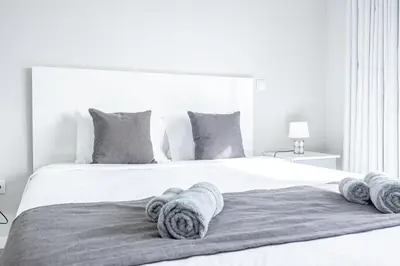 a white bedroom with a large bed with towels on it at Paradise Pereira House BY YOUR KEY MADEIRA in Calheta