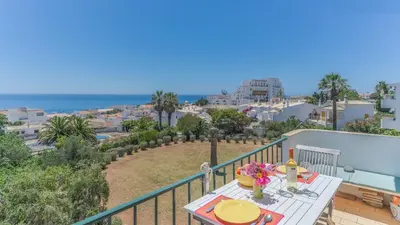 a balcony with a table and a view of the ocean at Casa dos Zefiros in Luz