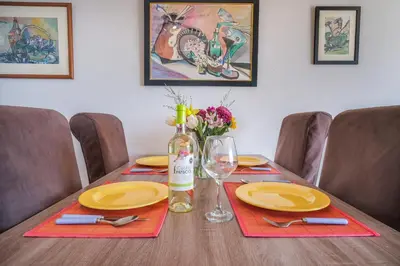 a table with yellow plates and a bottle of wine at Casa dos Zefiros in Luz