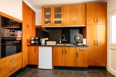a kitchen with wooden cabinets and a white dishwasher at Casa Silva, Calheta in Calheta