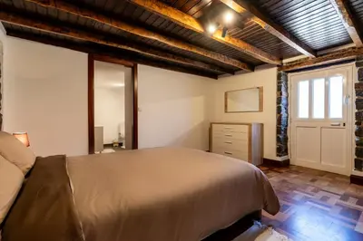 a bedroom with a large bed and a window at Casa Silva, Calheta in Calheta