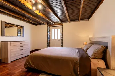 a bedroom with a bed and a dresser and a mirror at Casa Silva, Calheta in Calheta