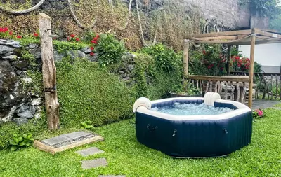 a hot tub in the grass in a garden at Casas das Hortas, Apartamento Vista Mar in Seixal