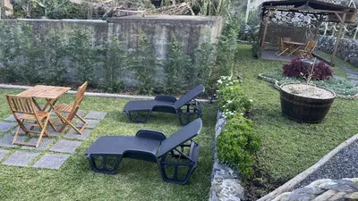 a backyard with chairs and a table and a table and chairs at Casas das Hortas, Apartamento Vista Mar in Seixal