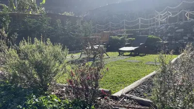 a garden with a table and a desk in the grass at Casas das Hortas, Apartamento Vista Mar in Seixal