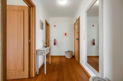 a hallway with a mirror and a wooden door at VeBella Ocean View in Caniço