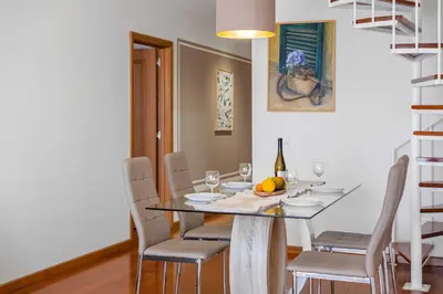 a dining room with a table with chairs and wine glasses at VeBella Ocean View in Caniço