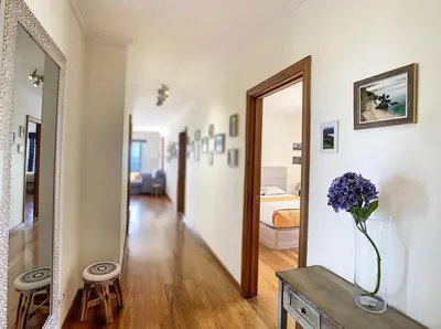 a hallway with a vase of purple flowers on a table at VeBella Ocean View in Caniço
