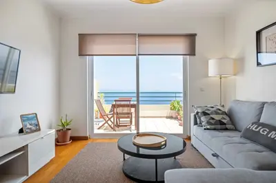 a living room with a couch and a view of the ocean at VeBella Ocean View in Caniço