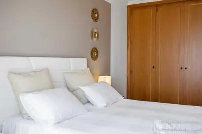 a white bed with white pillows in a bedroom at VeBella Ocean View in Caniço