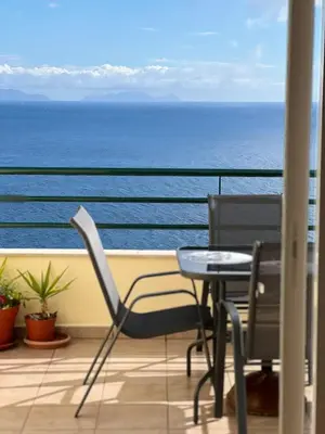 a balcony with a table and chairs and the ocean at VeBella Ocean View in Caniço