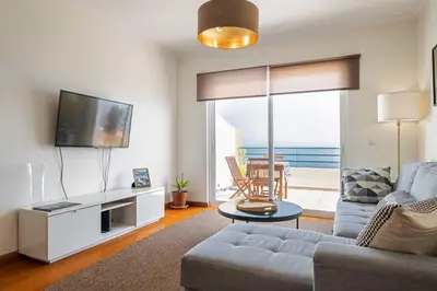 a living room with a couch and a tv at VeBella Ocean View in Caniço