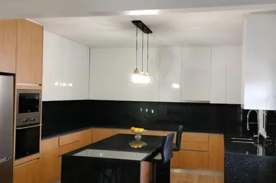 a kitchen with a table and a black counter top at Casa Neto Jardim in Calheta