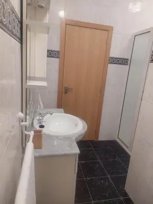 a white bathroom with a sink and a mirror at Casa Neto Jardim in Calheta