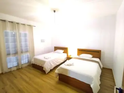 a bedroom with two beds and a window at Casa Neto Jardim in Calheta