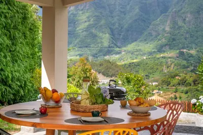 a table with fruit on it with a view of a mountain at OurMadeira - Casa Hortensia in Senhora do Rosário