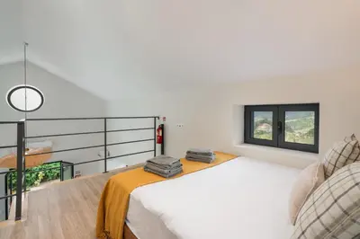 a bedroom with a large bed and a balcony at OurMadeira - Casa Hortensia in Senhora do Rosário