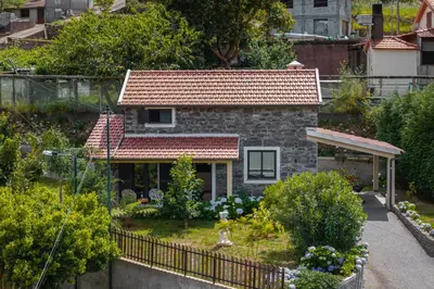 a small stone house with a red roof at OurMadeira - Casa Hortensia in Senhora do Rosário