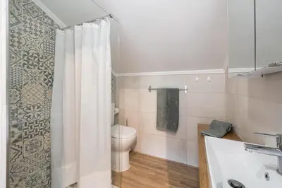 a bathroom with a toilet and a shower curtain at OurMadeira - Casa Hortensia in Senhora do Rosário