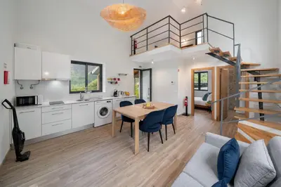 a kitchen and a living room with a table and chairs at OurMadeira - Casa Hortensia in Senhora do Rosário