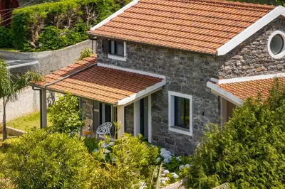 a stone house with an orange roof at OurMadeira - Casa Hortensia in Senhora do Rosário
