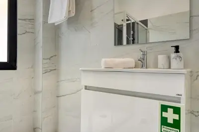 a white bathroom with a sink and a mirror at Beco Santa Emilia 1C, a Home in Madeira in Funchal