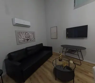 a living room with a black couch and a table at Pretas Village Flats in Funchal