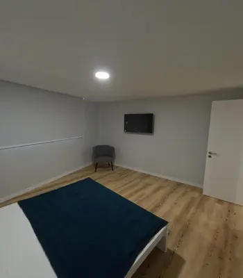a room with a bed and a black chair at Pretas Village Flats in Funchal