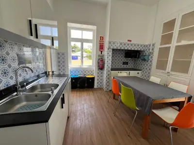 a kitchen with a sink and a table with chairs at Lazareto 148 Hostel in Funchal