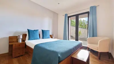 a bedroom with a bed and a chair and a window at Mon Rêve Portugais by LovelyStay in Funchal