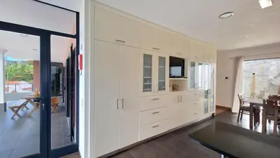 a kitchen with white cabinets and a dining room at Mon Rêve Portugais by LovelyStay in Funchal