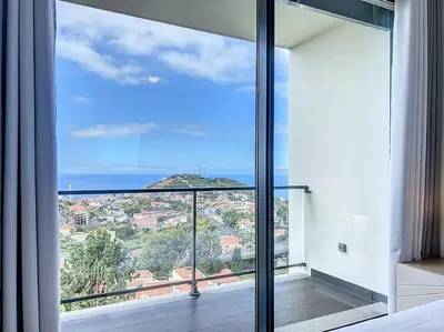 a room with a large window with a view of the ocean at Villa Ribeiro Real 12 A in Câmara de Lobos