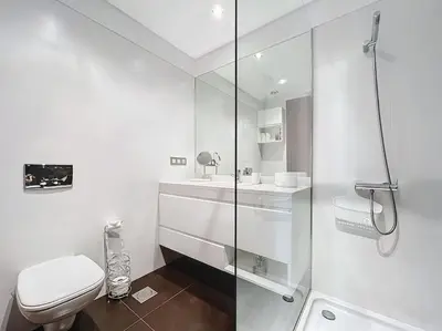 a white bathroom with a toilet and a shower at Villa Ribeiro Real 12 A in Câmara de Lobos
