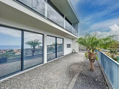 a house with a balcony with a view of the ocean at Villa Ribeiro Real 12 A in Câmara de Lobos