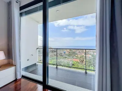 a room with a large window with a view of the ocean at Villa Ribeiro Real 12 A in Câmara de Lobos