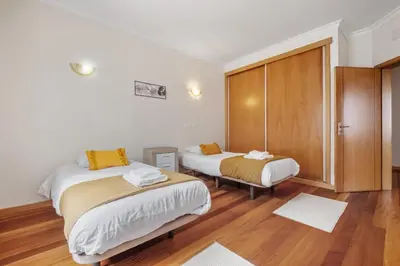 a bedroom with two beds and a sliding glass door at Atlantic Ocean Breeze in Ponta do Sol