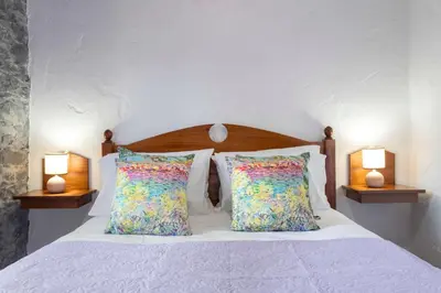 a bedroom with a bed with pillows and two lamps at Villa Roque by An Island Apart in Calheta