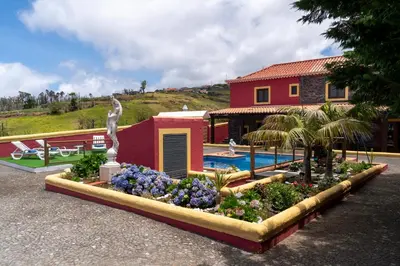 a statue in a flower bed in front of a house at Villa Roque by An Island Apart in Calheta