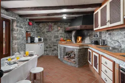 a kitchen with a large stone fireplace in a kitchen at Villa Roque by An Island Apart in Calheta