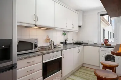 a kitchen with white cabinets and a microwave at Apartamento Ilha Dourada by An Island Apart in Porto Santo