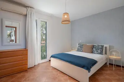 a bedroom with a bed with blue sheets and a window at Apartamento Ilha Dourada by An Island Apart in Porto Santo