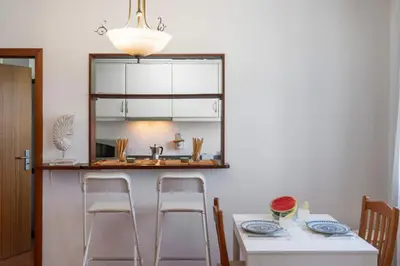 a kitchen with a table and two stools at Apartamento Ilha Dourada by An Island Apart in Porto Santo