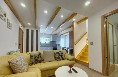 a living room with a yellow couch and a table at Celeiro do Avô in Santana