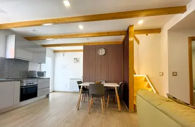 a kitchen and living room with a table and a couch at Celeiro do Avô in Santana