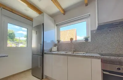 a kitchen with a sink and two windows at Celeiro do Avô in Santana